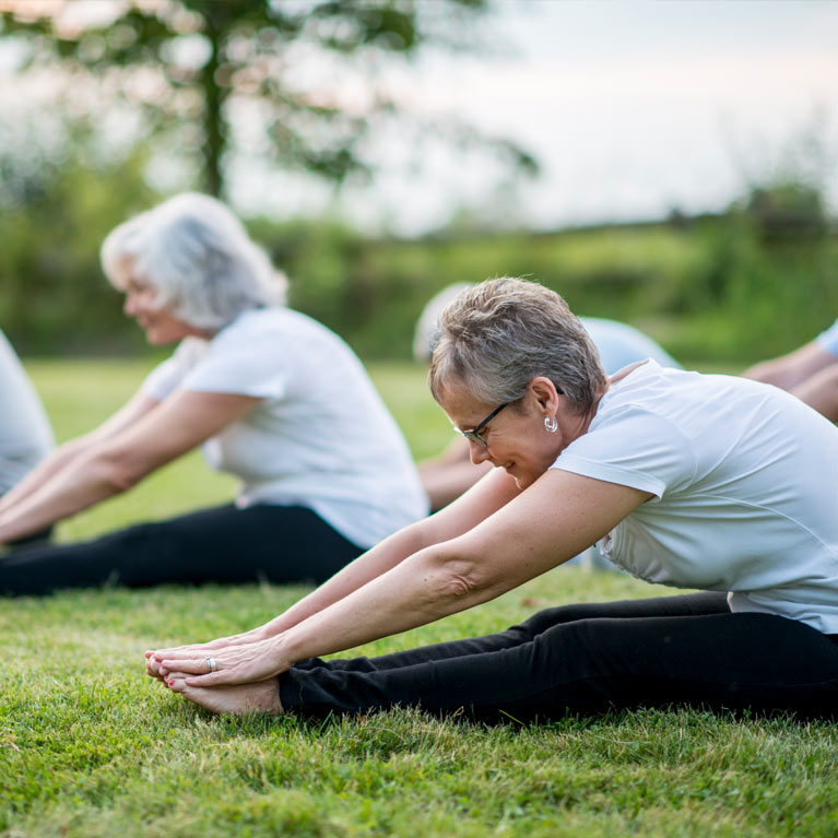 Anglicare Minto Gardens - group of seniors doing yoga outdoors